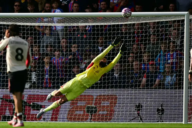 Liverpool's Brazilian goalkeeper #01 Alisson Becker dives as Crystal Palace's French striker #14 Jean-Philippe Mateta hits the woodwork