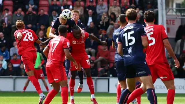 Carl Piergianni (second left) jumps to head the ball