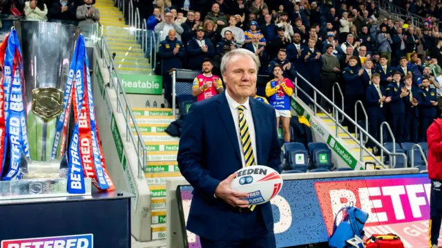 Leeds chief executive Gary Hetherington carries the ball out