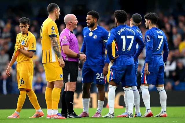 Referee Simon Hooper talks with Reece James of Chelsea