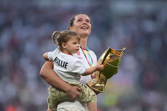 Abbie Ward of England hold the Women's World Cup Trophy with her daughter Hallie