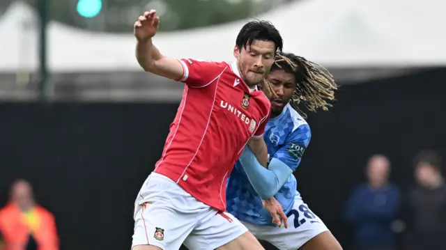 Wrexham’s Kieffer Moore (left) and Derby County's Dion Sanderson battle for the bal