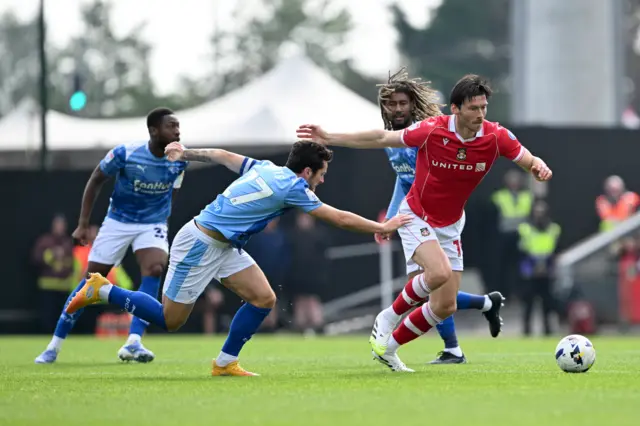 Derby County's Lewis Travis and Wrexham’s Kieffer Moore (right) battle for the ball
