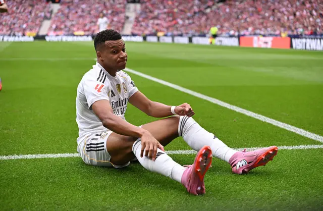 Mbappe sits on the pitch after being fouled