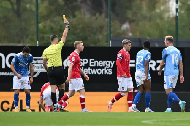 Referee Tom Nield shows Derby County's Ebou Adams (second right) a yellow card