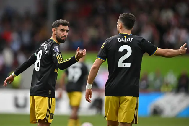 Bruno Fernandes (L) gestures to Manchester United's Portuguese defender #02 Diogo Dalot (R) after they concede