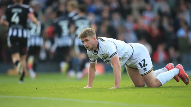 Darragh Power on his hands and knees on the pitch after Grimsby score