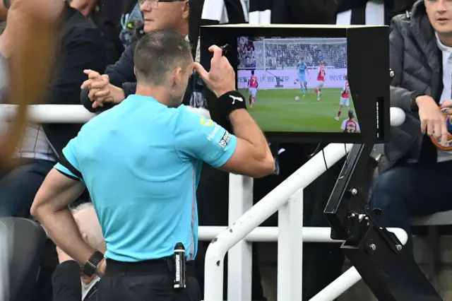Australian referee Jarred Gillett checks the pitch-side monitor