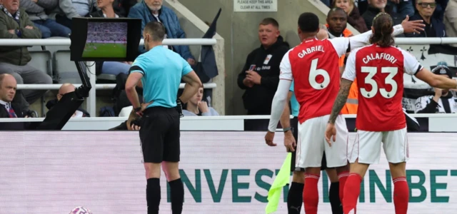 Referee Jarred Gillett looks at a VAR screen during a penalty kick review