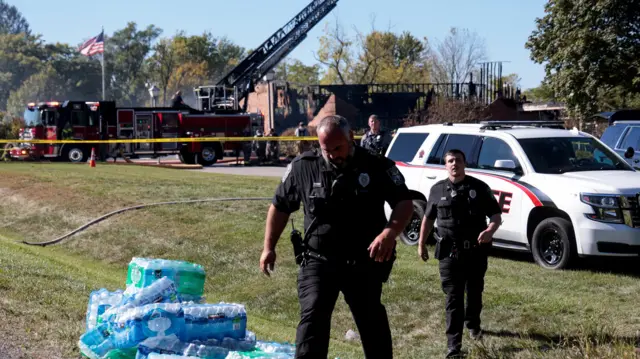 Law enforcement officers work near burnt-out church