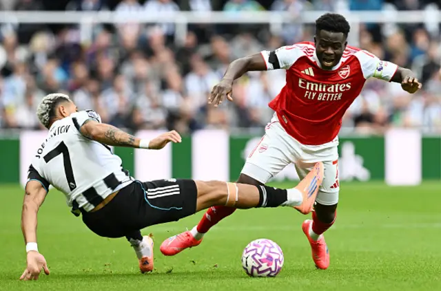 Bukayo Saka of Arsenal is tackled by Joelinton