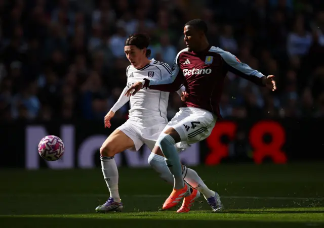 Harry Wilson and Ezri Konsa compete for the ball