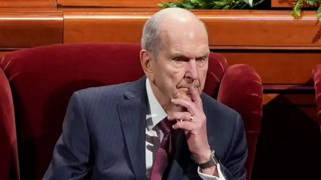 Russell M Nelson sits on a chair