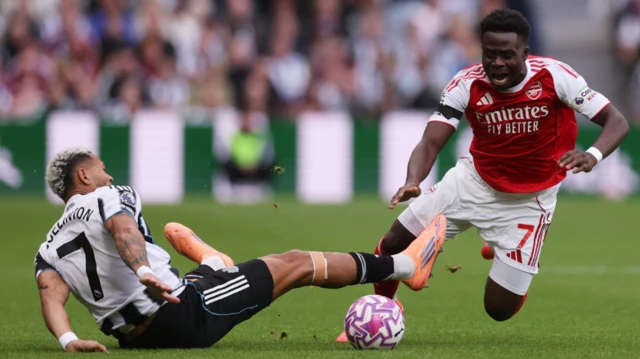 Newcastle United's Joelinton in action with Arsenal's Bukayo Saka