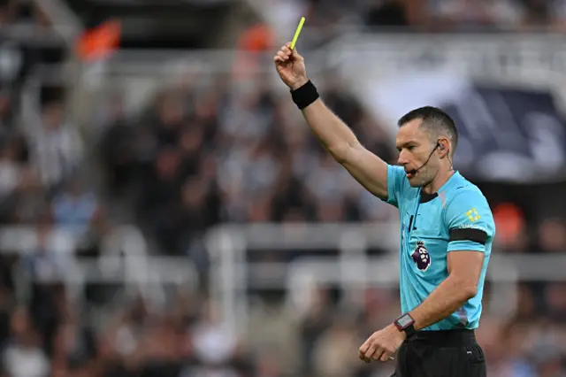 Australian referee Jarred Gillett shows a yellow card