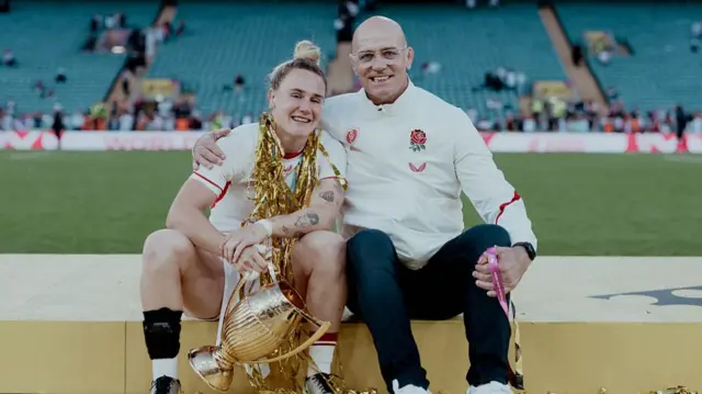 Meg Jones, holding the trophy, and John Mitchell