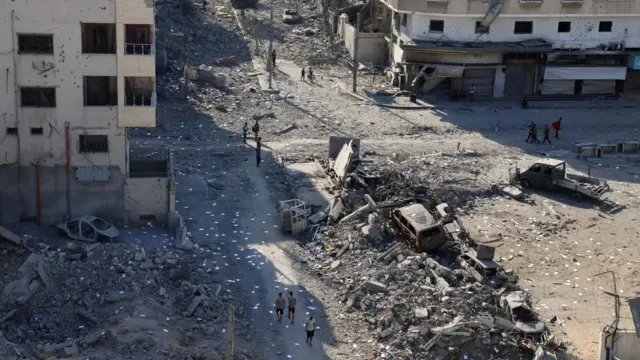 Palestinians inspect the damage following an Israeli raid, amid an Israeli military operation, in Gaza City