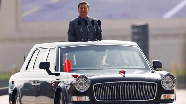 Chinese President Xi Jinping stands in a car