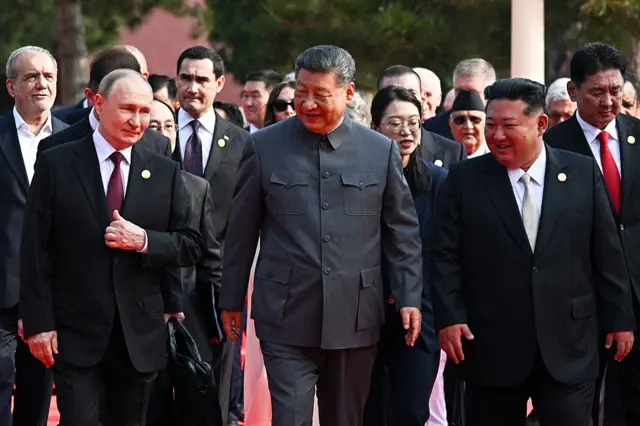 In this pool photograph distributed by the Russian state agency Sputnik, (L-R) Russia's President Vladimir Putin walks with China's President Xi Jinping and North Korea's leader Kim Jong Un