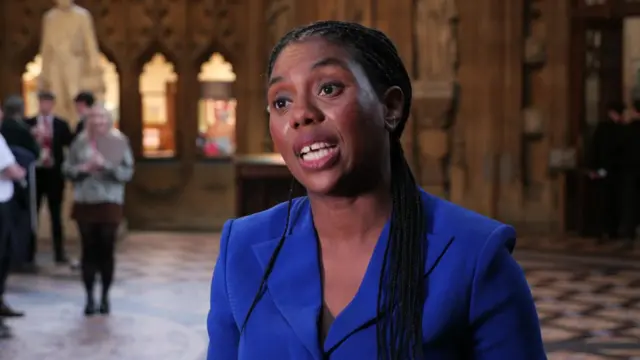 Kemi Badenoch in the halls of the Commons wearing a blue blazer