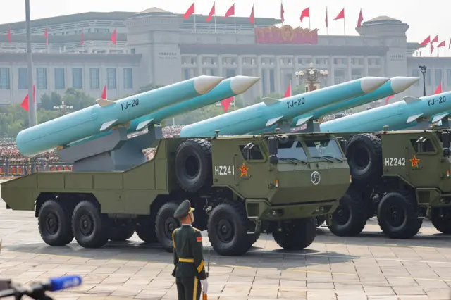 A member of the People's Liberation Army stands as the maritime operations group displays YJ-20 hypersonic anti-ship missiles