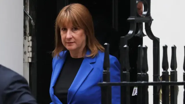 Rachel Reeves in blue suit emerging from Downing Street door.