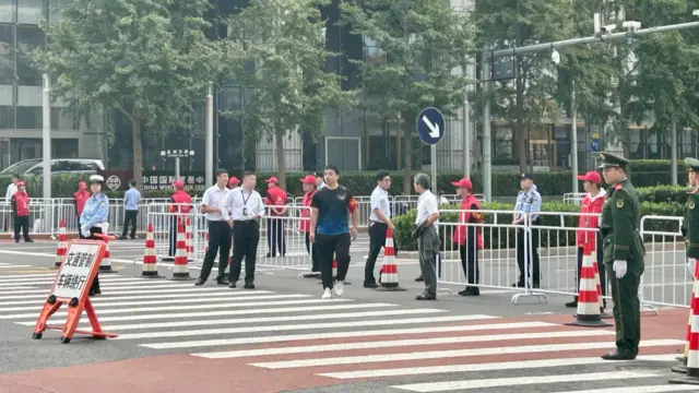 People at a pedestrian crossing that has been barricaded