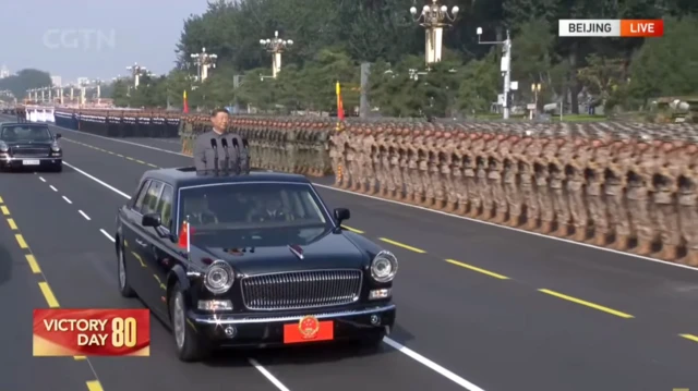 Xi in car inspecting troops