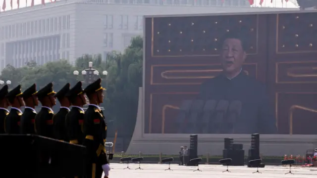 Xi appears on screen at parade in front of soldiers.