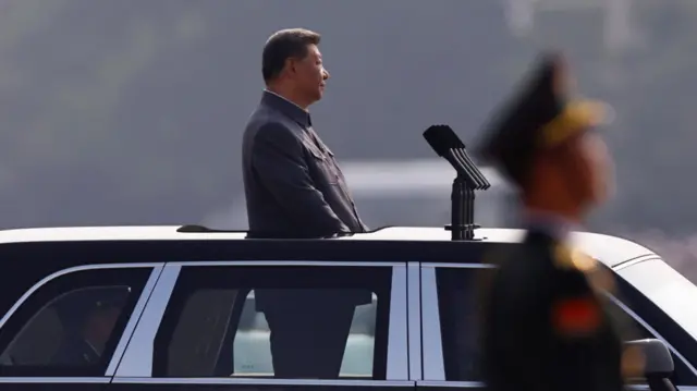 Xi in car inspecting troops.