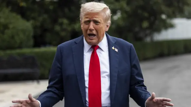 Donald Trump in blue suit with red tie.