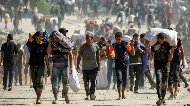 People carrying aid packages they have received from a distribution centre run by the US- and Israeli-backed Gaza Humanitarian Foundation in central Gaza