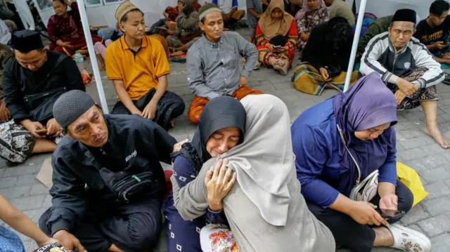 A relative of a victim of a collapsed building reacts, after a hall collapsed while students were praying at the Al-Khoziny Islamic boarding school in Sidoarjo, East Java