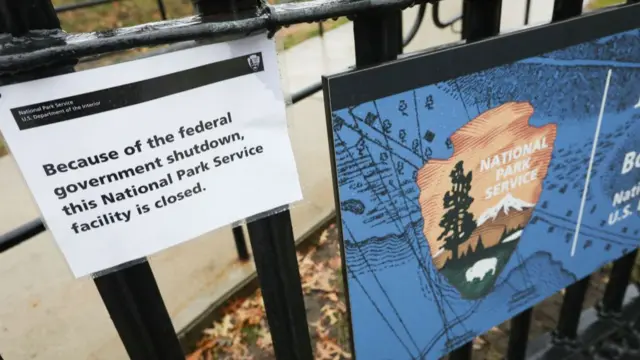 A sign attached to a black metal fence that says because of the shutdown the service is closed.