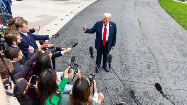 US President Donald Trump speaks to reporters as he departs the White House