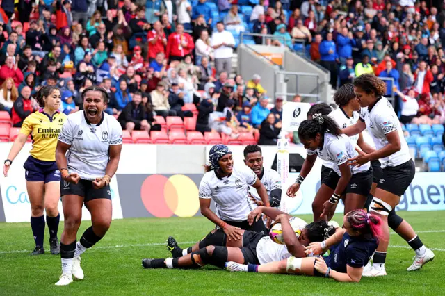 Loraini Senivutu of Fiji celebrates with teammates after scoring against Scotland