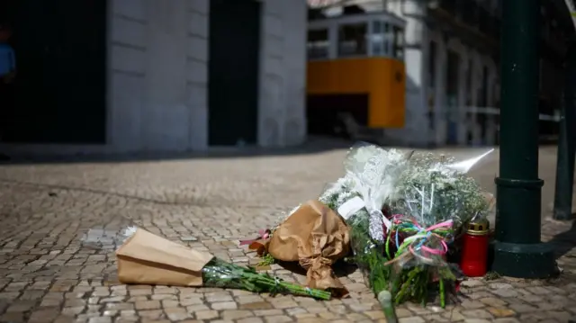 Flowers are seen near the site of the accident after Gloria funicular railway car