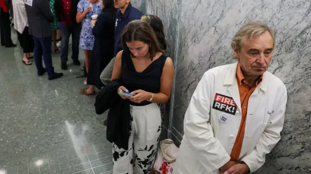Dr. Troy Jacobs, a Washington-area pediatrician, wears a lab coat with a ''FIRE RFK'' sticker as he is among the first in line to be in the public gallery to watch a Senate Finance Committee hearing on President Donald Trump's 2026 health care agenda, on Capitol Hill in Washington, D.C., U.S., September 4, 2025.