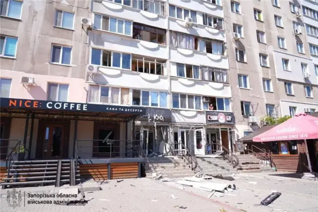 Damage to the front of a building and debris on the pavement