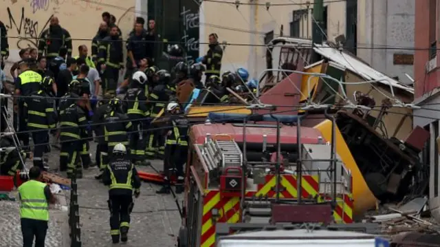 police and firefighters work on the site of the Gloria funicular railway accident in Lisbon