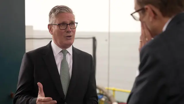 Keir Starmer speaks to Chris Mason outside, with the sea seen in the background