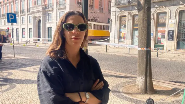 Local woman Margardia Moura stands with her arms folded