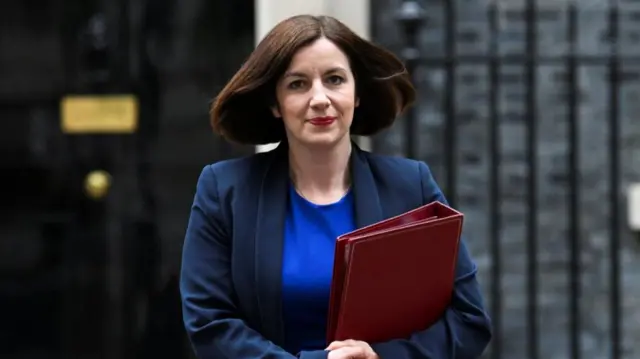 Bridget Phillipson holds a red folder and wears a suit as she walks away from Downing Street