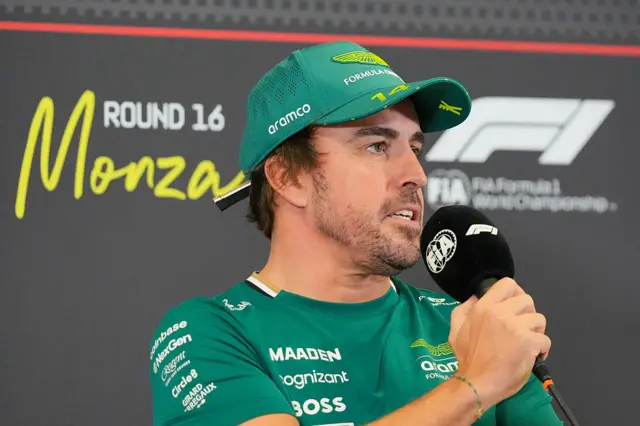 Fernando Alonso holding an FIA and F1-branded microphone during a news conference
