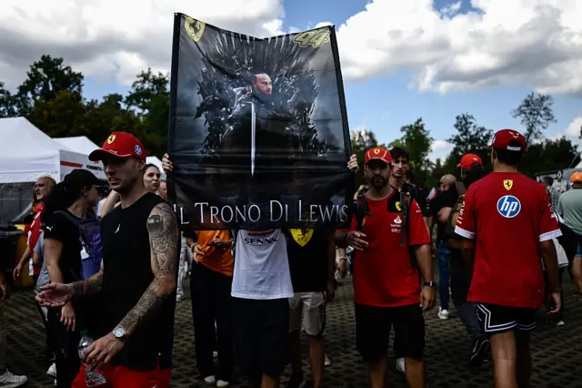 An Italian fan holds a sign with Lewis Hamilton emblazoned with "The Throne of Lewis" in Italian