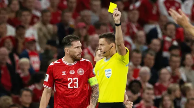 Referee Daniel Siebert shows a yellow card to Denmark's Pierre-Emile Hojbjerg