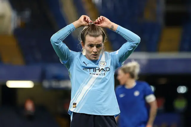 Lauren Hemp of Manchester City looks on as she adjusts her hair