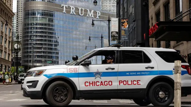 A Chicago police car in the foreground with one of the Trump Organizations buildings in the background