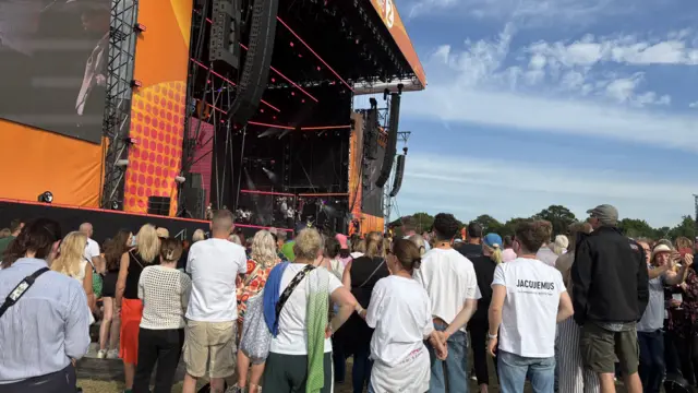 Another view of crowds watching a band perform on stage.
