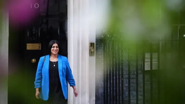 Shabana Mahmood wears a green blazer and black top and smiles while leaving 10 Downing Street.